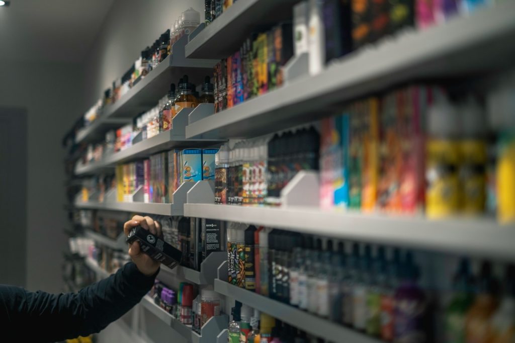 person holding a vape liquid inside a vape store