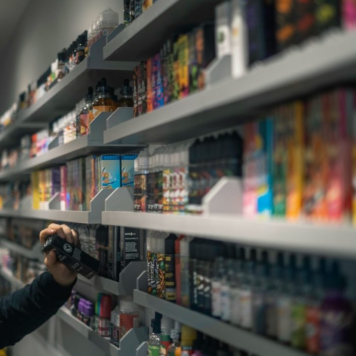person holding a vape liquid inside a vape store