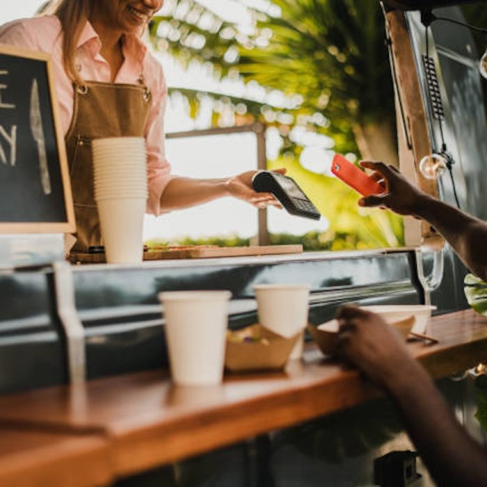 African man making contactless payment at food truck restaurant