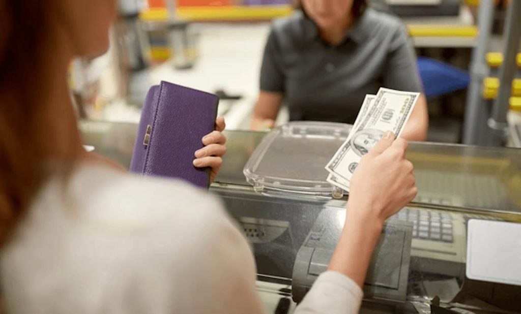 woman shopping paying using cash at cashier