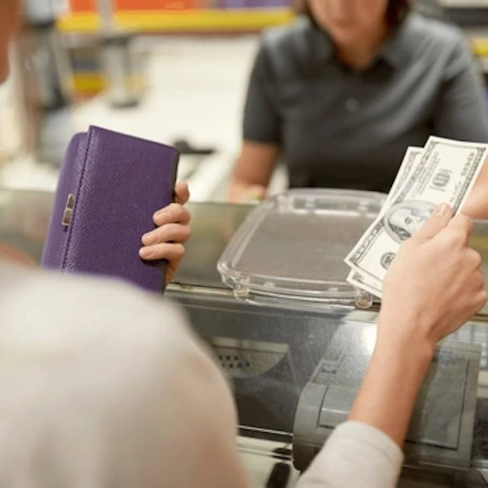 woman shopping paying using cash at cashier
